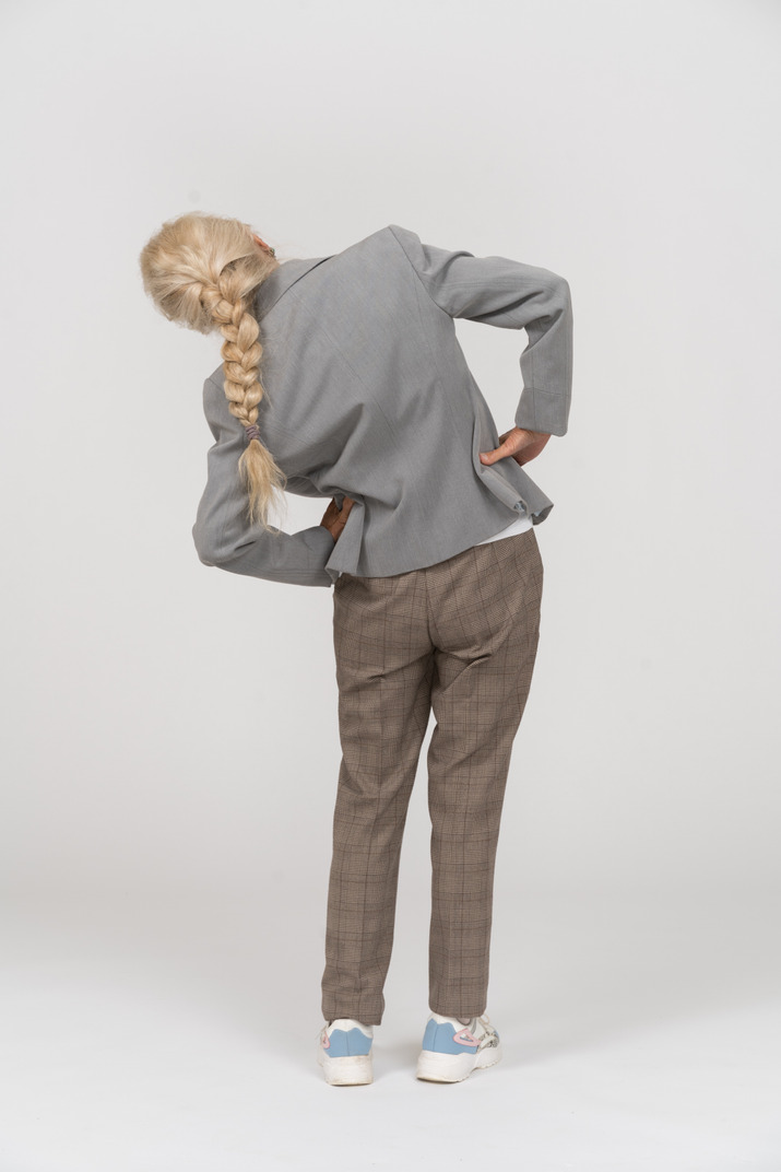 Rear view of an old lady in suit doing exercices