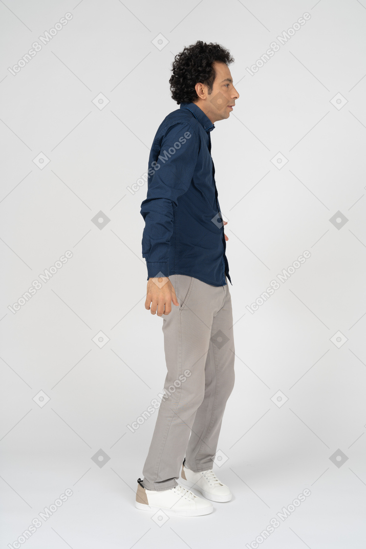 Homem com roupas casuais em pé de perfil