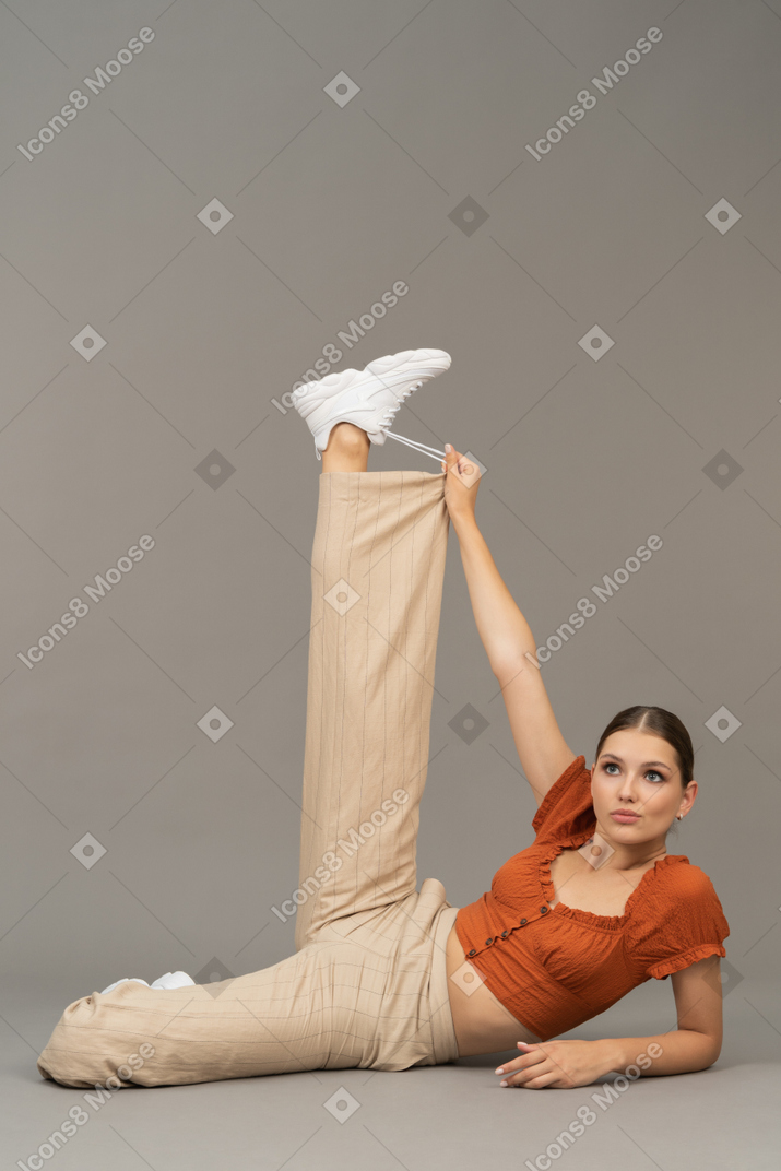 Young woman with raised leg and hand