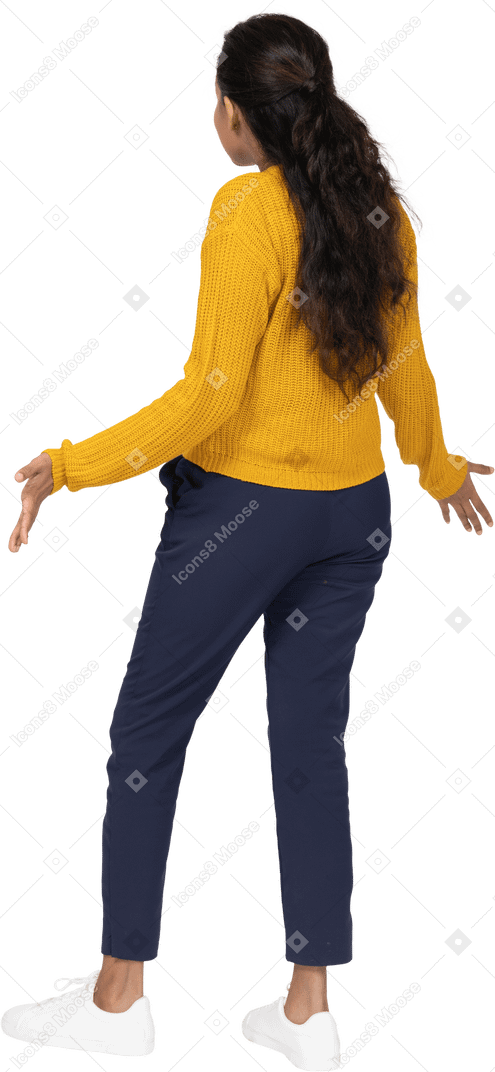 Rear view of a girl in casual clothes standing with outstretched arms