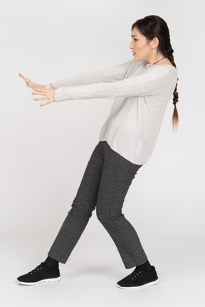 Brunette female bending backwards with outstretched arms making a stay away gesture