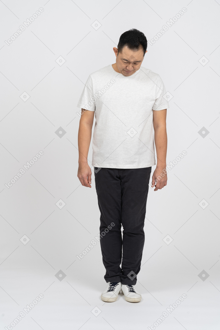 Front view of a man in casual clothes bending head down