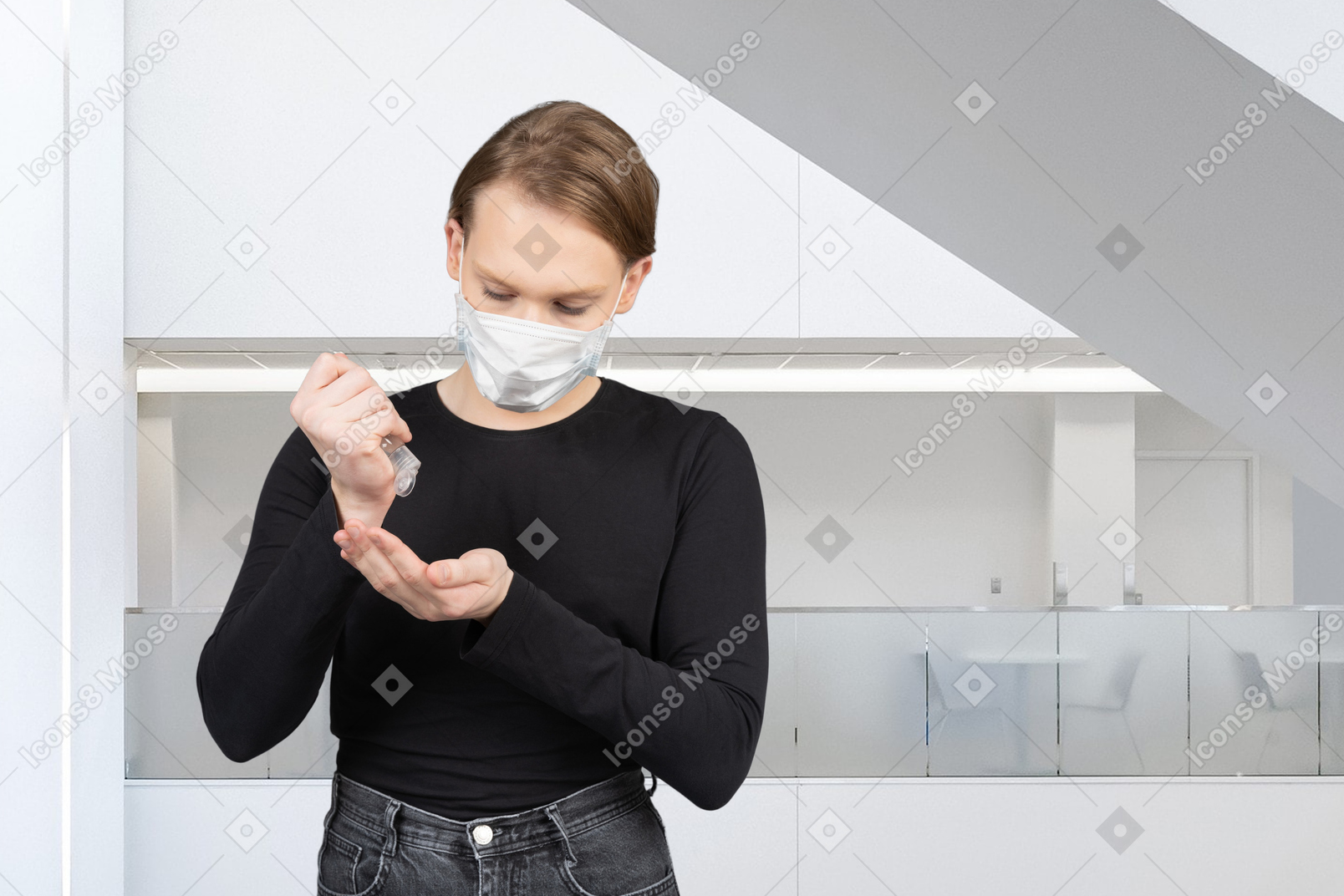 Woman in face mask applying hand sanitizer in a room