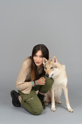 Mulher bonita posando com seu cachorro para uma câmera