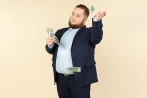 A plus-size man in a black costume with dollar bills in his hands