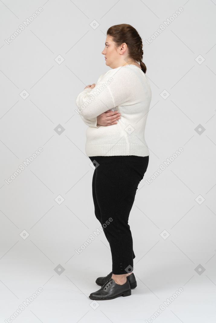 Donna grassoccia in abiti casual in posa con le braccia incrociate