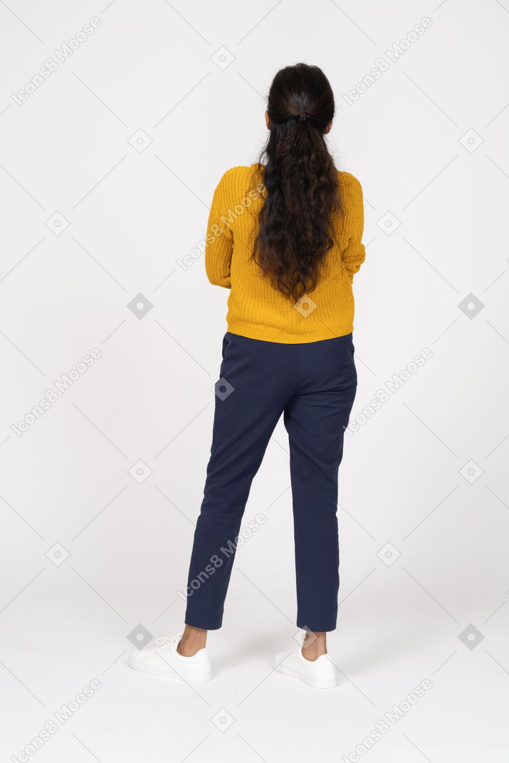 Rear view of a girl in casual clothes posing with crossed arms