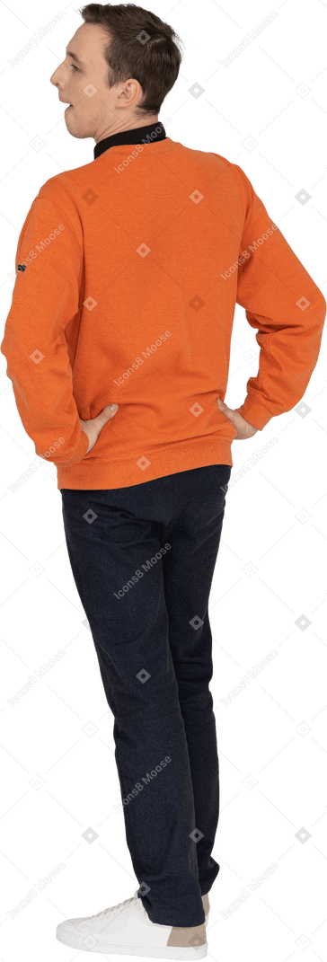 Young man in orange sweatshirt standing