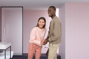 A man and a woman holding hands in a bathroom