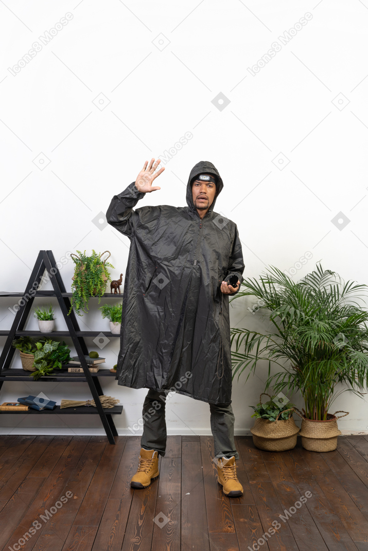 Man in raincoat waving hello