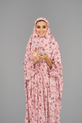 Cheerful covered woman with mobile phone