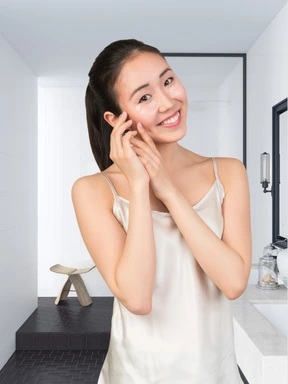 A woman putting on makeup in a bathroom