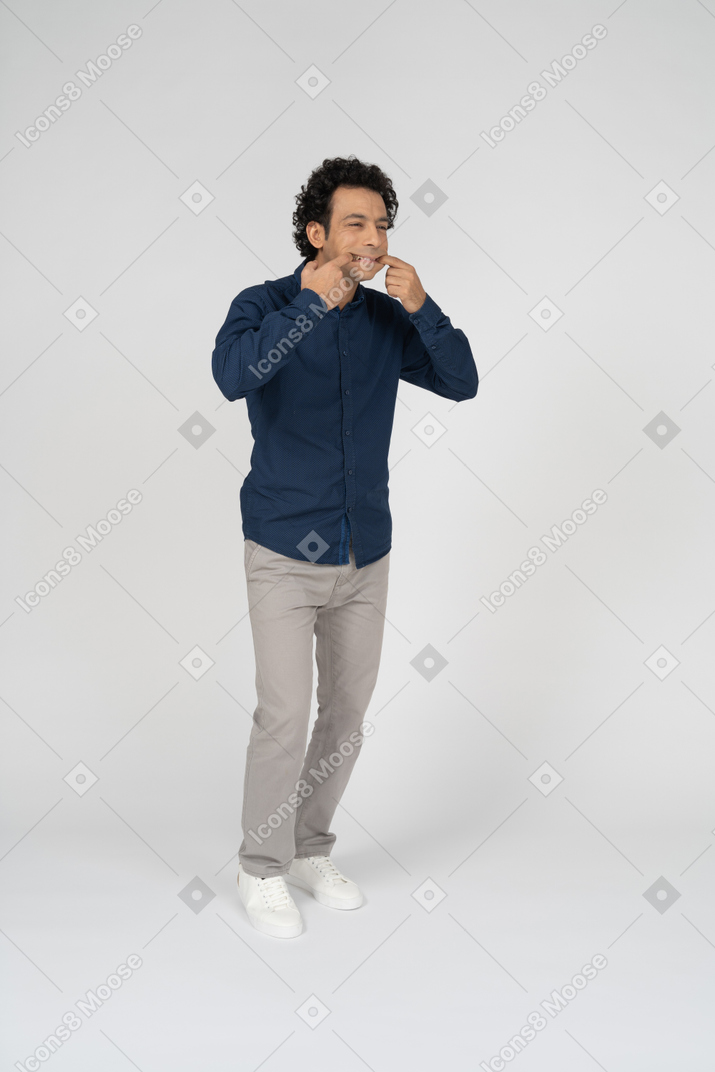 Vista frontal de um homem com roupas casuais tocando sua boca
