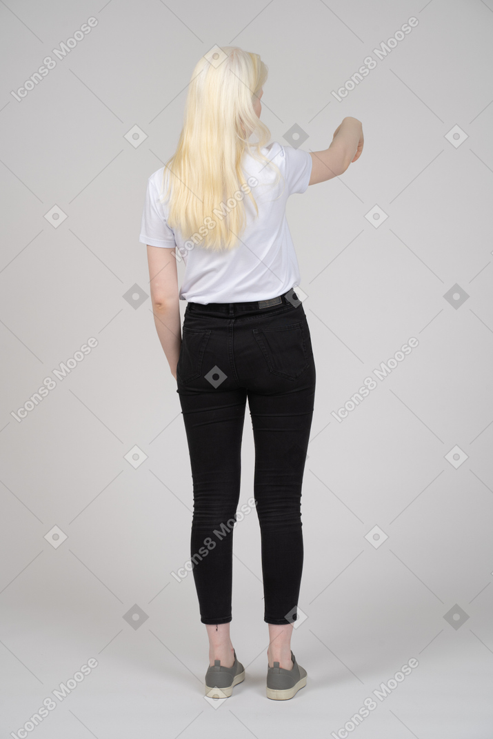 Back view of girl gesturing with outstretched hand