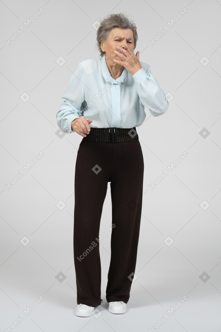 Old woman standing and yawning