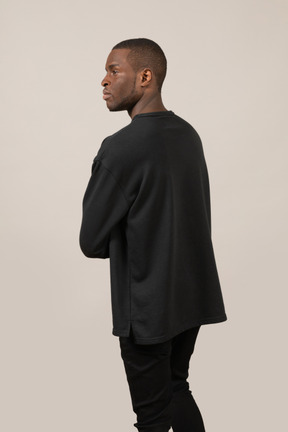 Three-quarter back view of young man looking aside