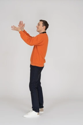 Young man in orange sweatshirt standing