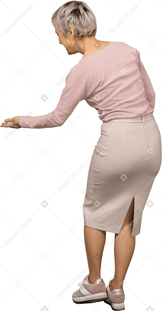 Vista posteriore di una donna in abiti casual che fa un gesto di benvenuto