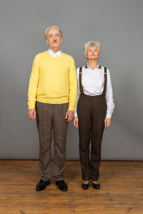 Man and woman standing with arms at sides