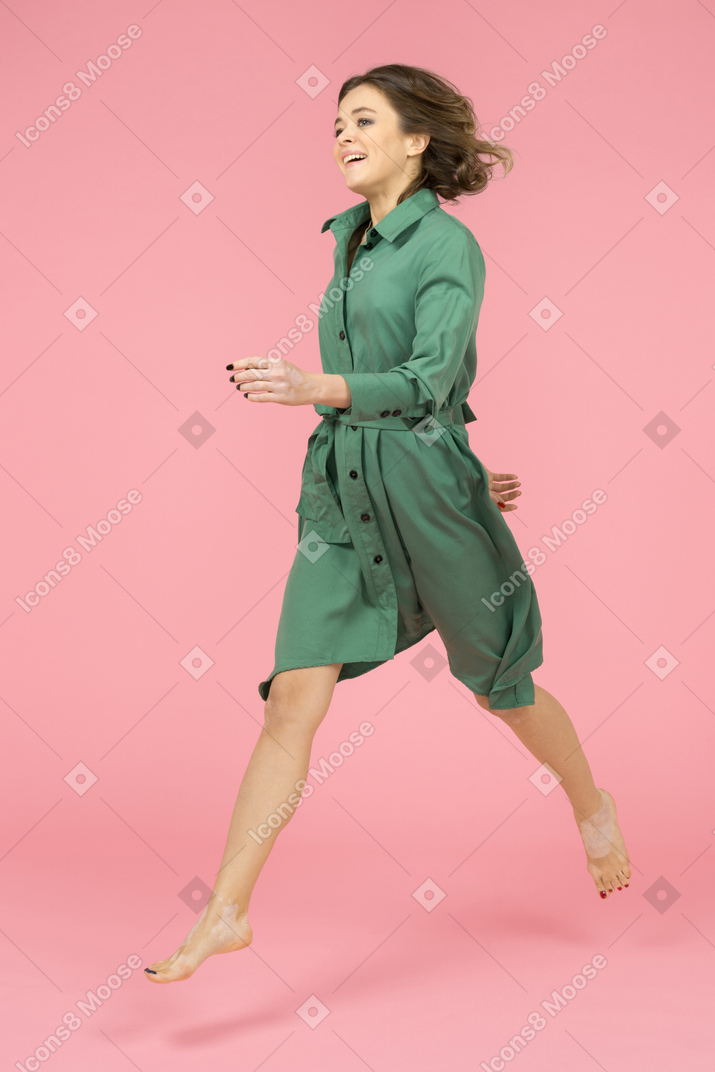 Счастливая девушка бежит боком шары к стене