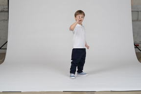 Vista de tres cuartos de un niño mirando a través de sus dedos