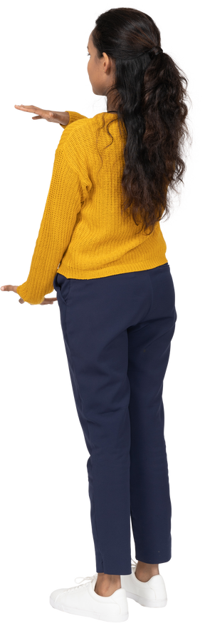 Vista traseira de uma garota com roupas casuais mostrando o tamanho de algo