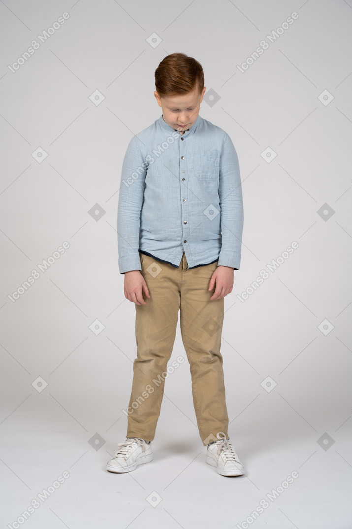 Front view of a boy in casual clothes bending head down