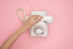 Mano femenina bajando el receptor del teléfono