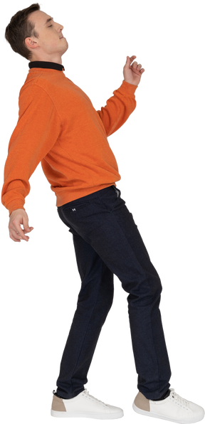 Молодой человек в оранжевой толстовке танцует