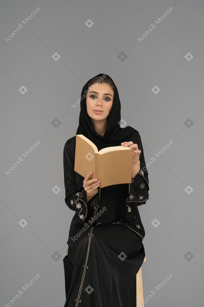 A young woman turning the pages of a book