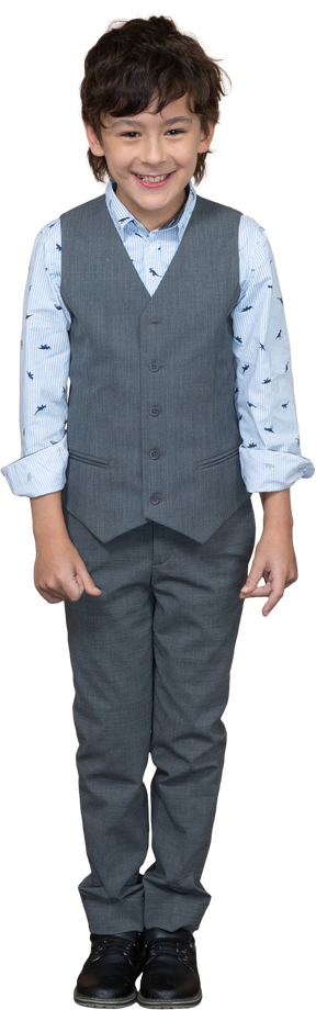 Front view of a happy boy in suit looking at camera