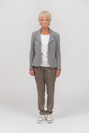 Front view of an old woman in grey jacket looking at camera