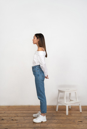 Young woman standing with hands behind her back