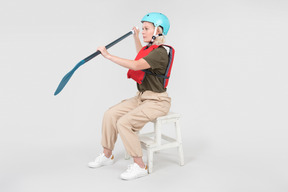 Mature woman in helmet sitting and learning how to paddle