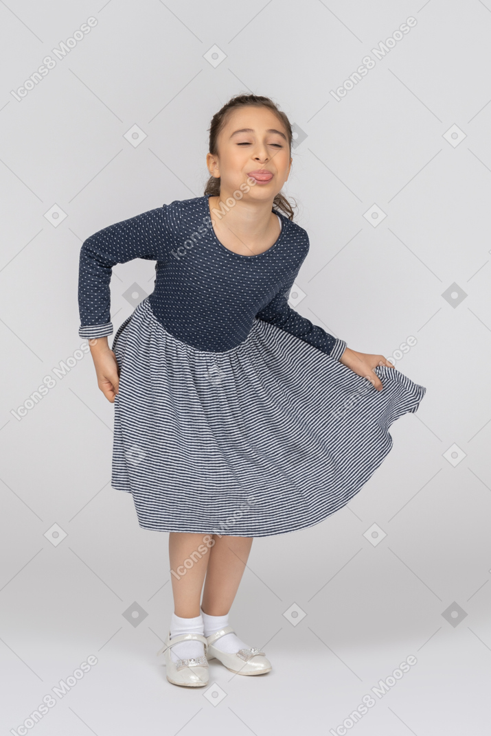 Young girl in blue dress sticking out her tongue