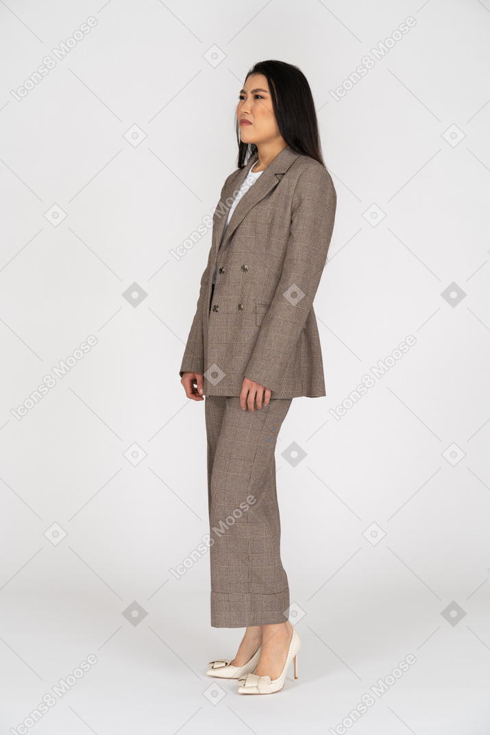 Three-quarter view of a smirking young lady in brown business suit