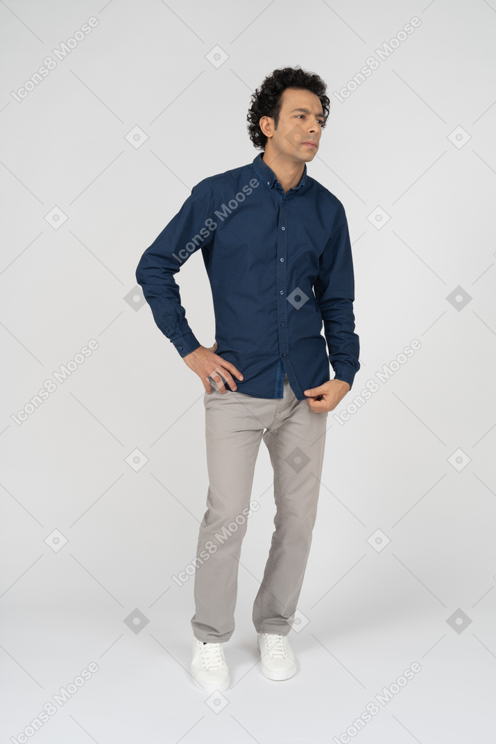 Vue de face d'un homme en vêtements décontractés debout avec la main sur la hanche