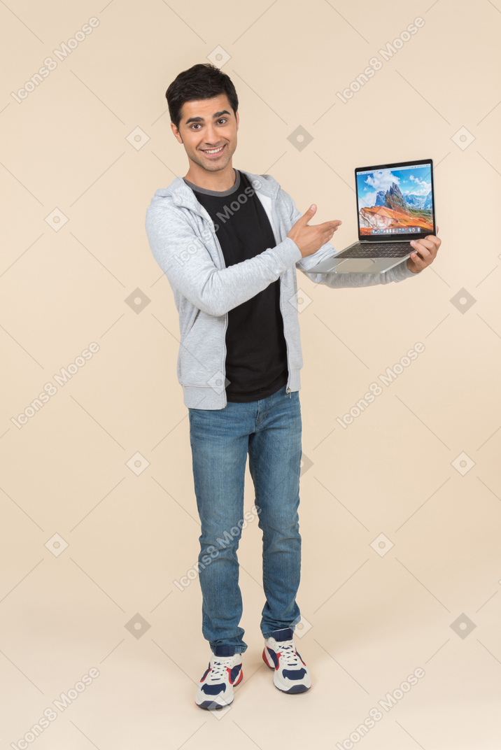 Молодой человек кавказской, представляя ноутбук