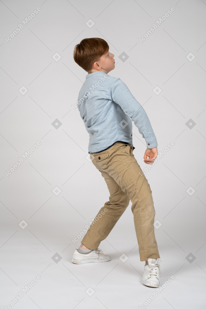 A young boy walking backwards