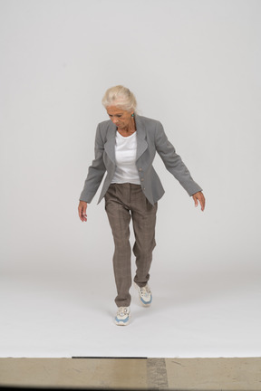 Vista frontale di una vecchia signora in abito in piedi con le braccia aperte