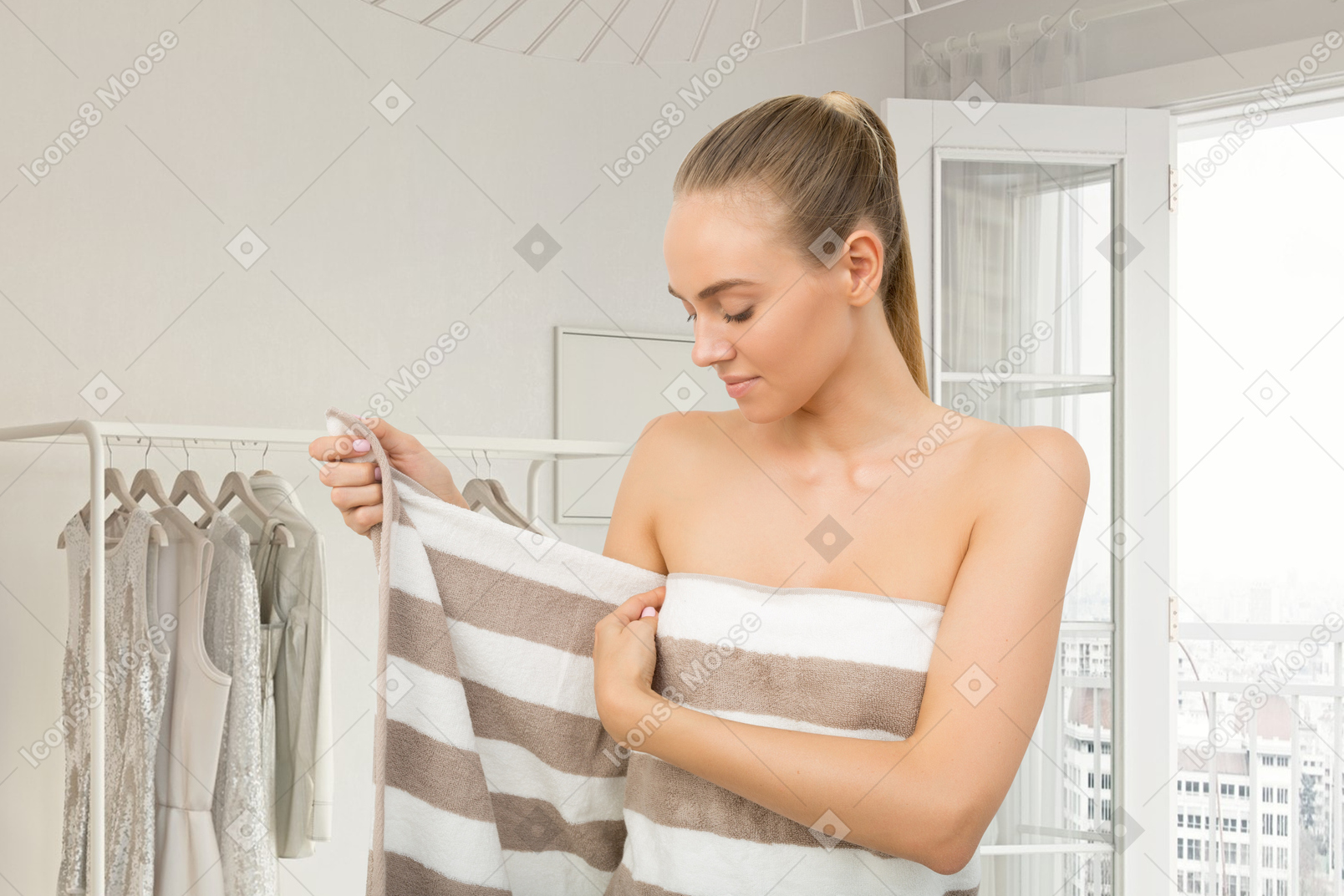 A woman in a bathroom wrapping herself in towel