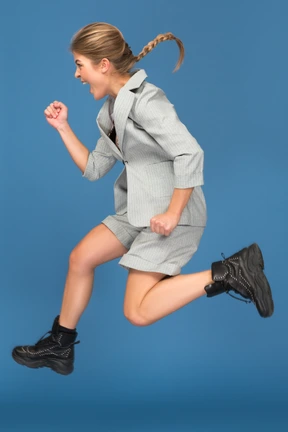 Joven excitada haciendo un gesto sí en un salto
