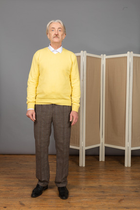 Front view of an old man standing still by the screen