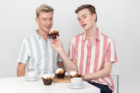 Beau jeune homme donnant un petit gâteau à son partenaire