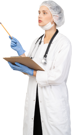 Vue de trois quarts d'une jeune femme médecin tenant un crayon et une tablette