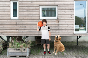 A boy and a dog standing in front of a house