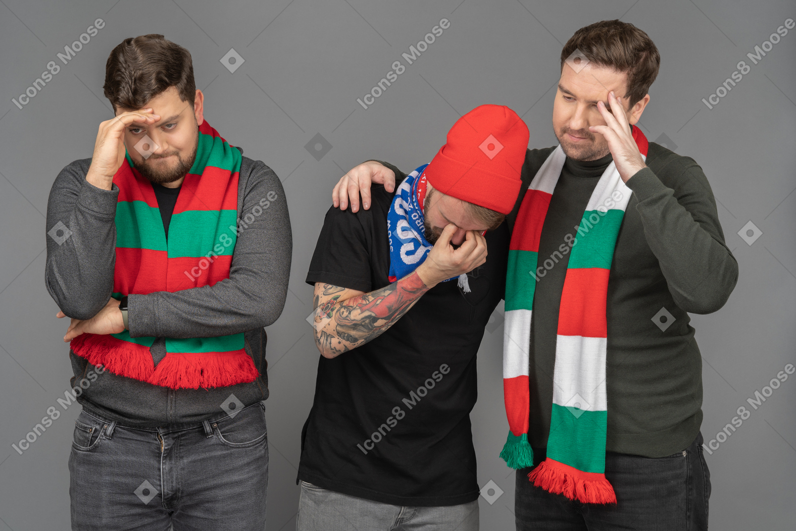 Front view of three sad male football fans touching head