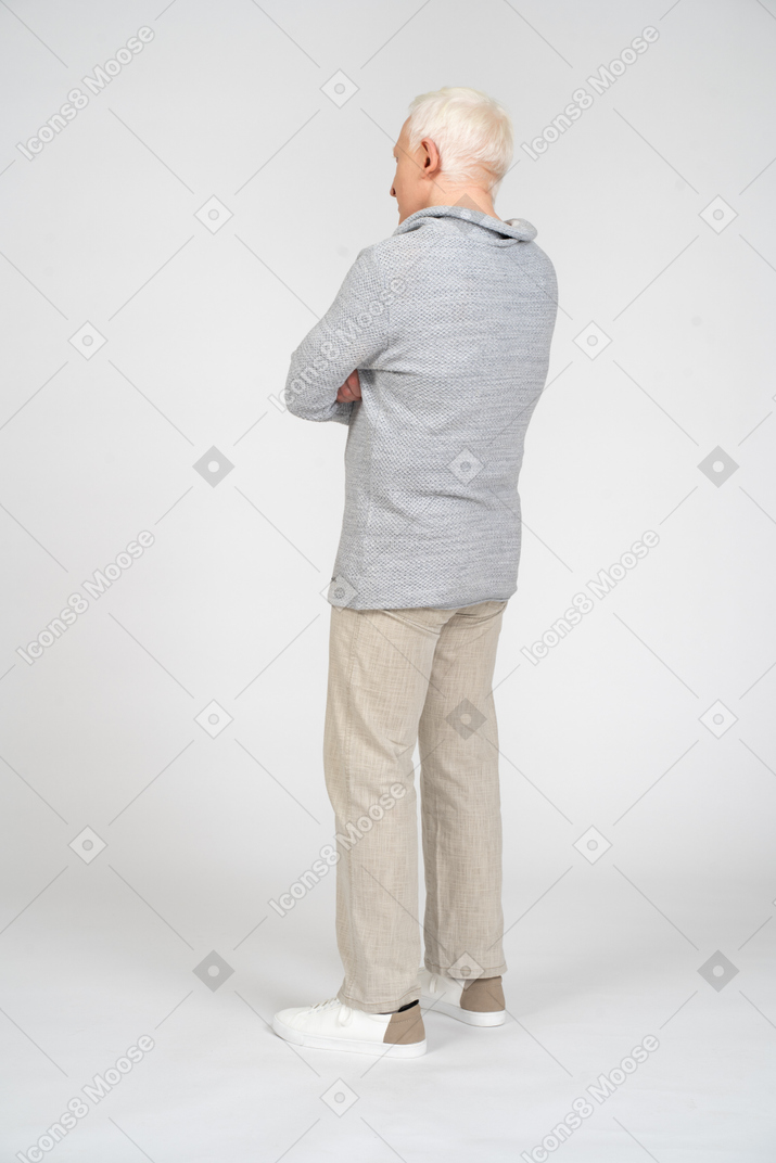 Vista posteriore di un uomo in piedi con le braccia incrociate