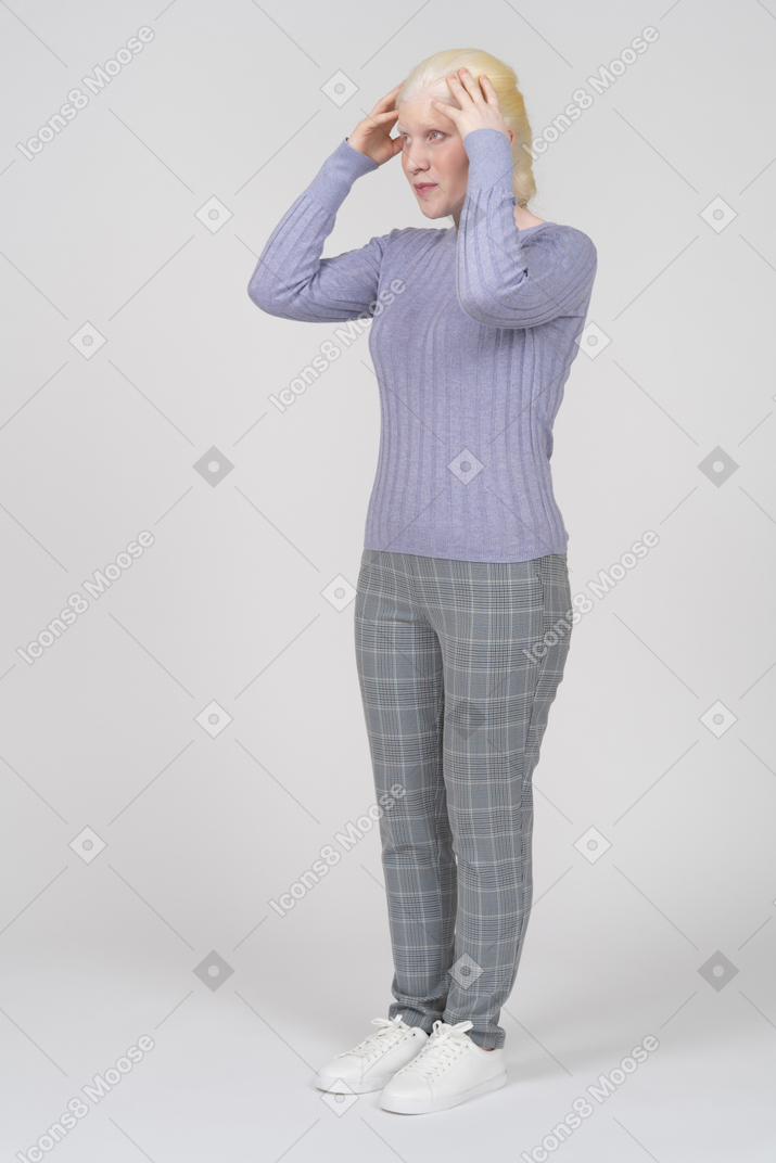 Woman in casual clothing resting hands on top of head