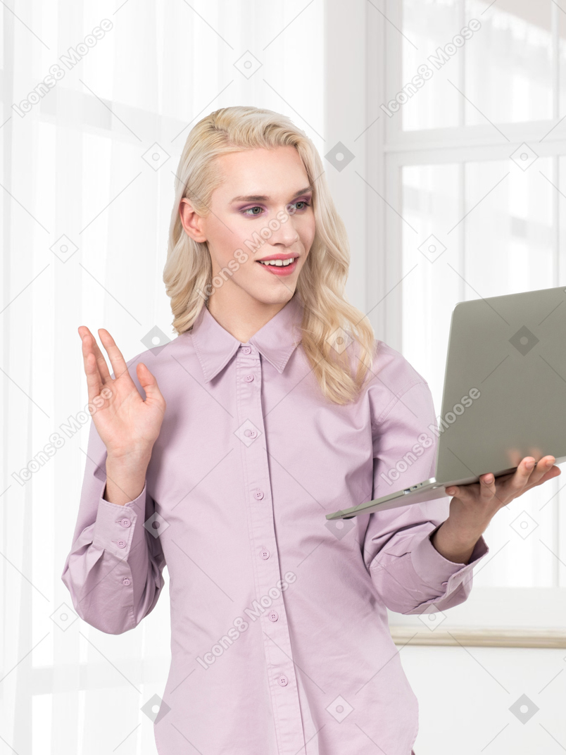 A woman in a purple shirt is holding a laptop